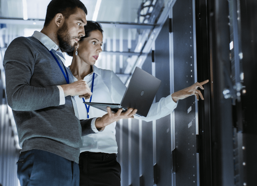 Engineers reviewing server racks in a datacentre
